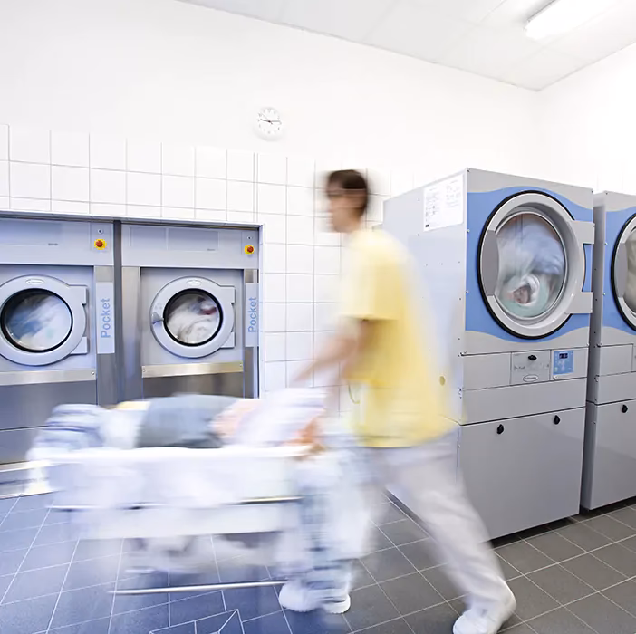 What training do laundry staff need to work with hospital linens?
